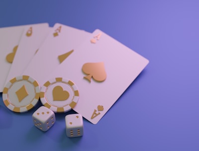 A set of playing cards displaying four aces is laid out on a surface. Alongside them, there are two poker chips with heart and diamond symbols, and three six-sided dice showing different numbers. The background is a smooth gradient of purple, creating a thematic gaming or casino atmosphere.
